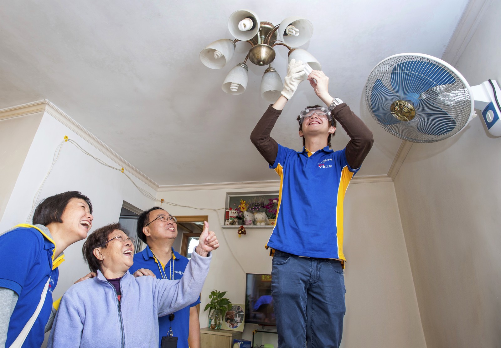 CLP volunteers installing LED light bulbs for the elderly